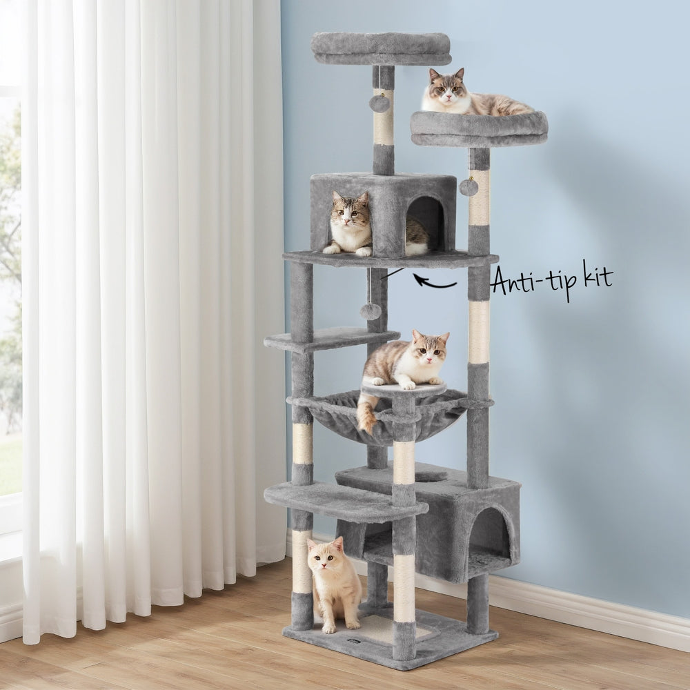 Cat tree with multiple levels and cats on a light blue wall background